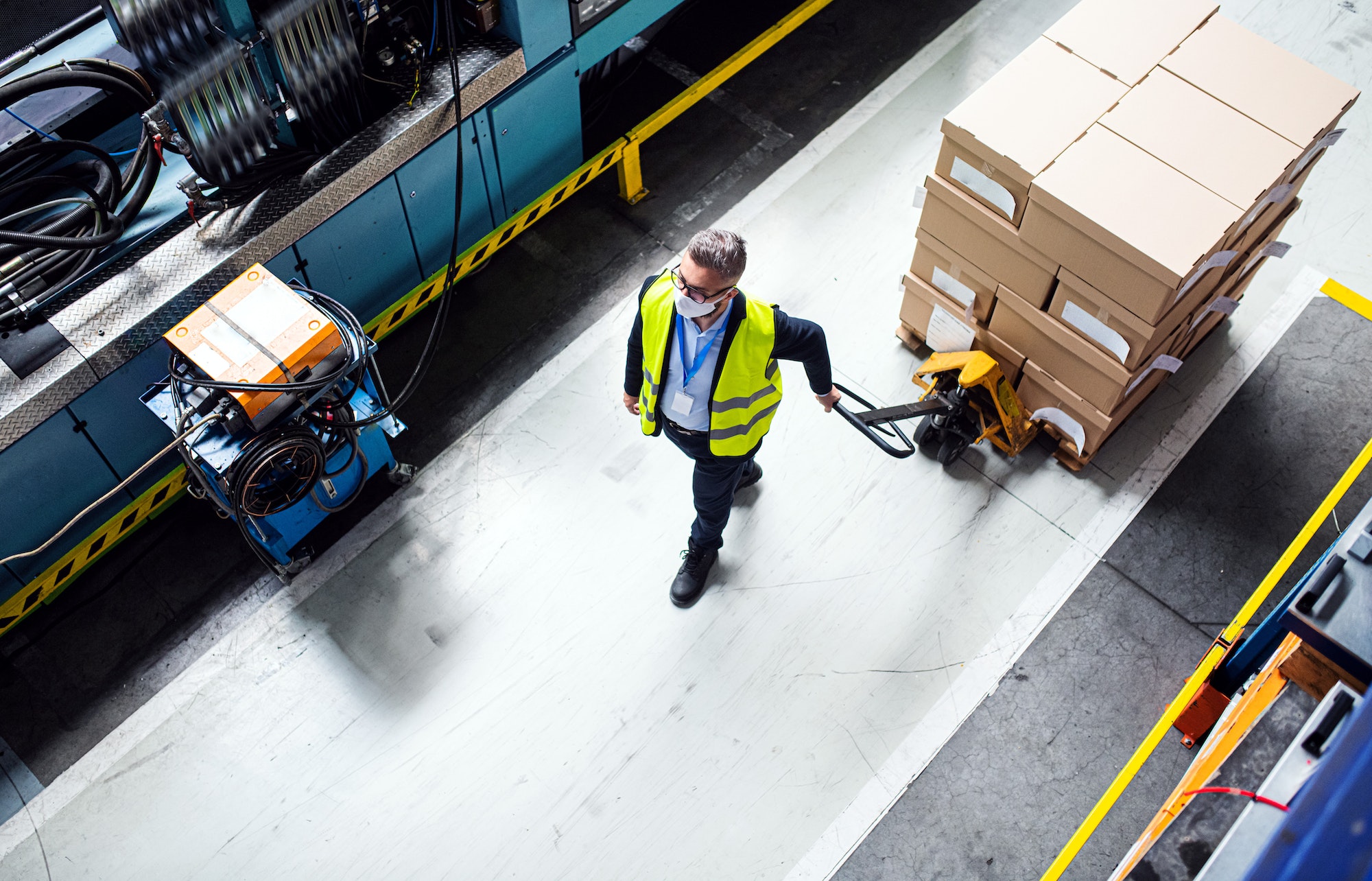 Aerial view of man worker with protective mask working in industrial factory or warehouse